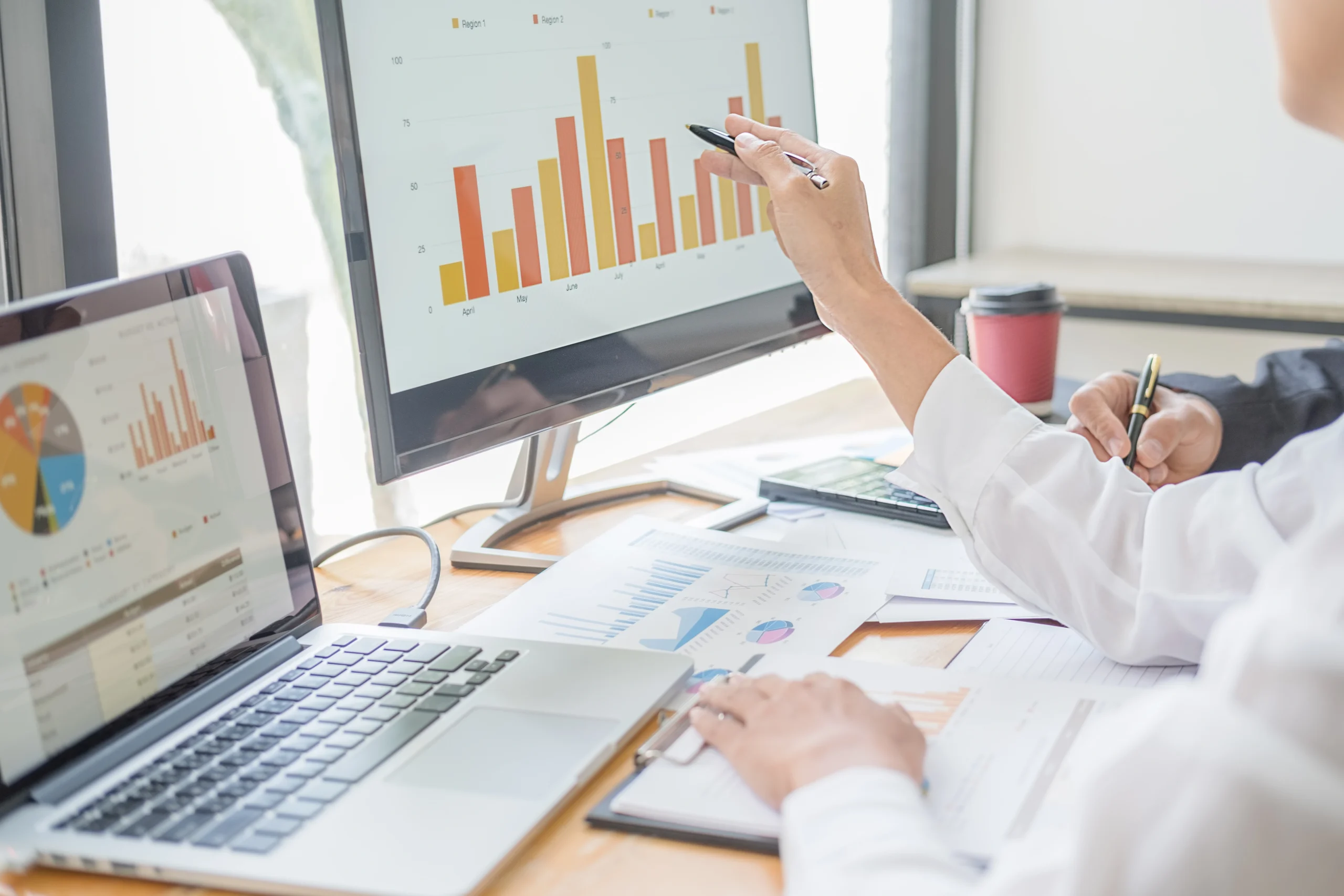 Team bei der Arbeit mit Diagrammen und Statistiken auf einem Computerbildschirm. Analyse und Optimierung von Bauprojekten durch präzise Datenbewertung.